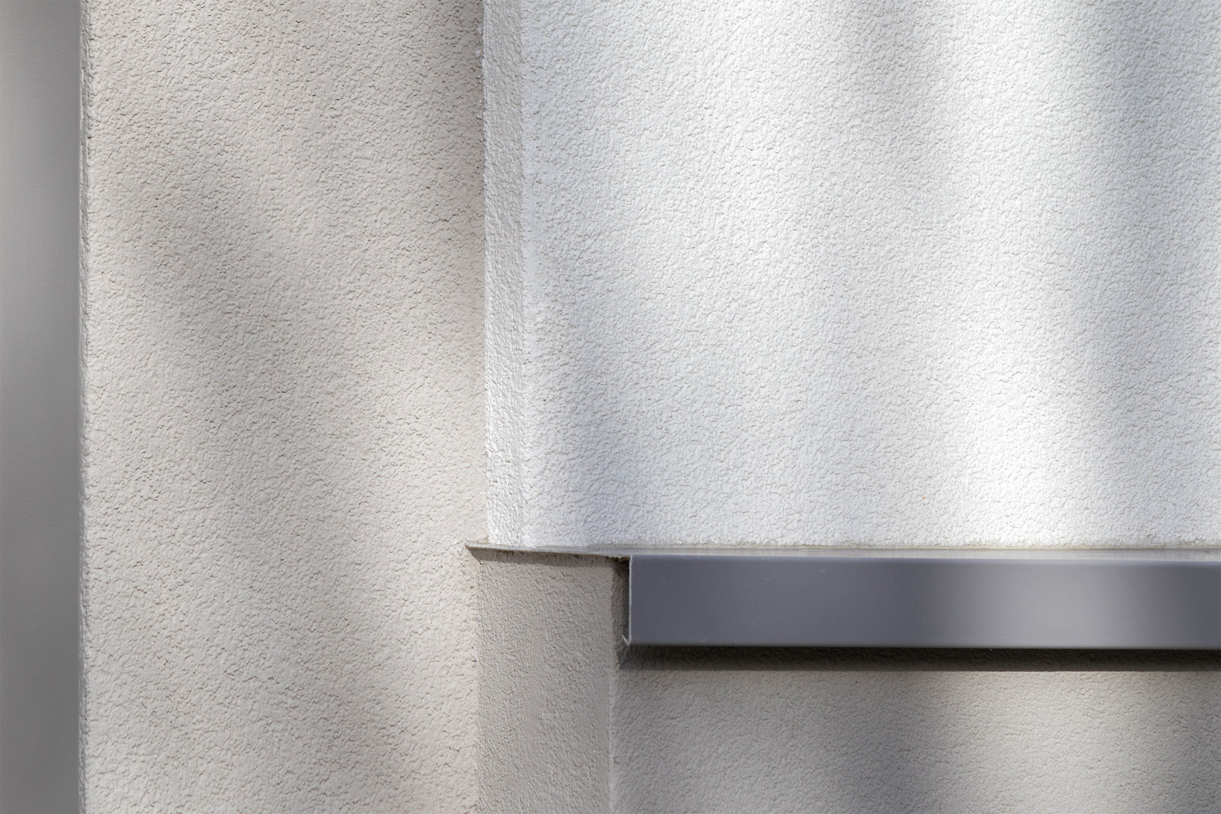 Deux teintes d’enduits sont retenues pour une harmonie intemporelle : un gris et un blanc